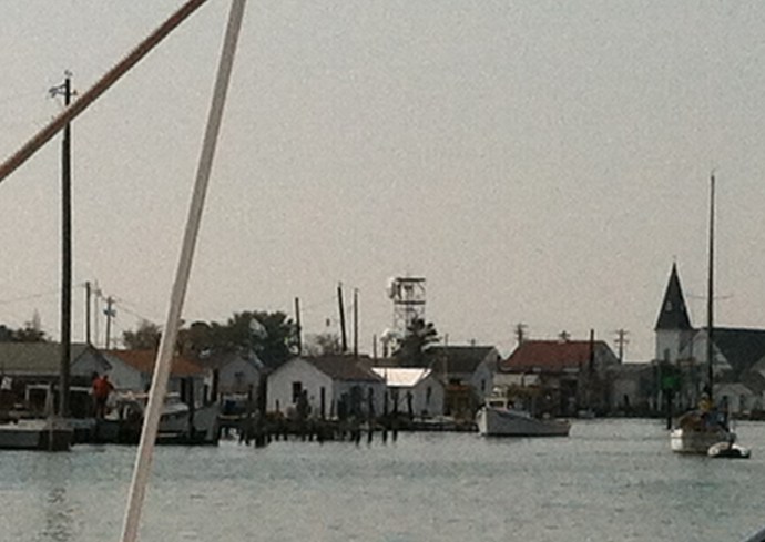 Patience glides slowly past the crab shacks that line the east channel into Tangier Island, VA.