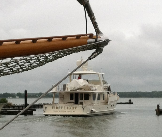 The 65' "First Light" motors past the bowsprit of the 100' schooner "Summer Wind" at rest at Bachelor's Point, Oxford.