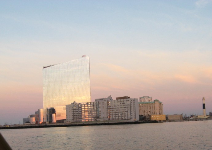 The glass monolith of the Revel Casino is brilliant in the light of the rising sun.