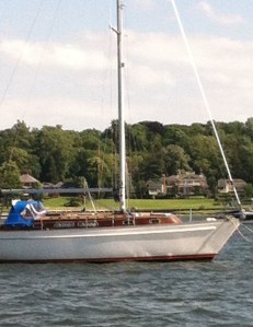 The foretriangle of a classic yacht frames another handsome estate on Oyster Bay.