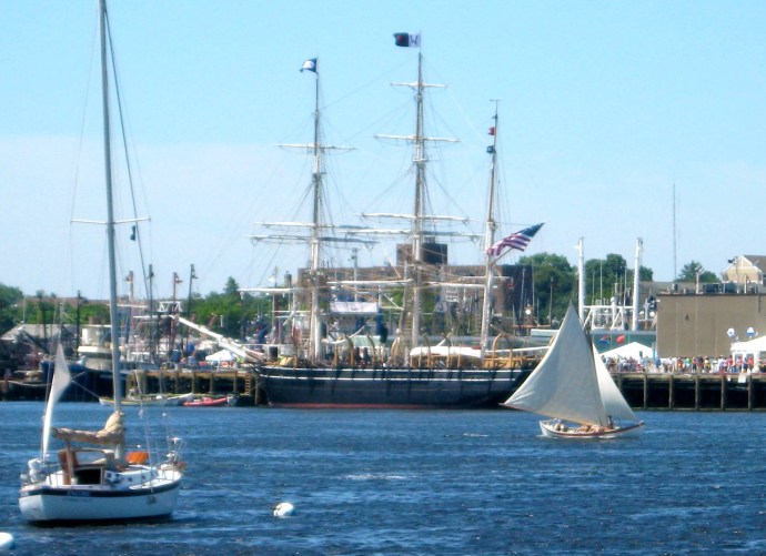 A whaleboat crew puts the blustery wind to good use as she races past the Charles W. Morgan.